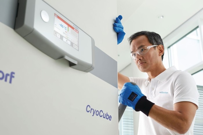 A man handling the ergonomically designed door handle of an Eppendorf CryoCube ULT freezer.