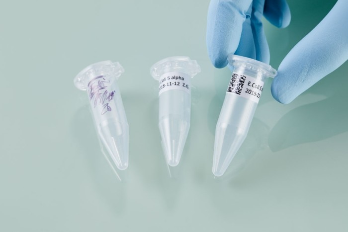 Three laboratory tubes with different types of labels from handwritten to datamatrix code.