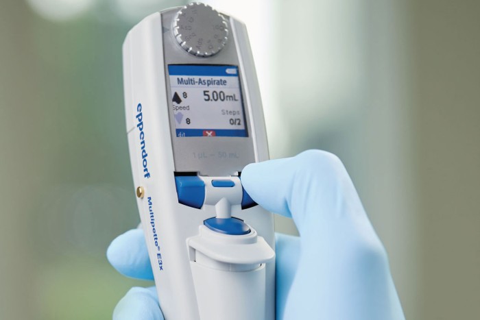 A person programming an electronic Eppendorf Xplorer pipette.