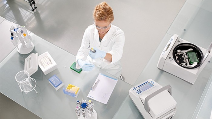 Scientist at lab bench, working ergonomically while pipetting