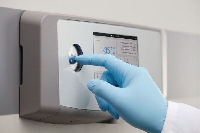 Scientist uses the vent-port button of an ultra low temperature freezer to perform the pressure equalization.