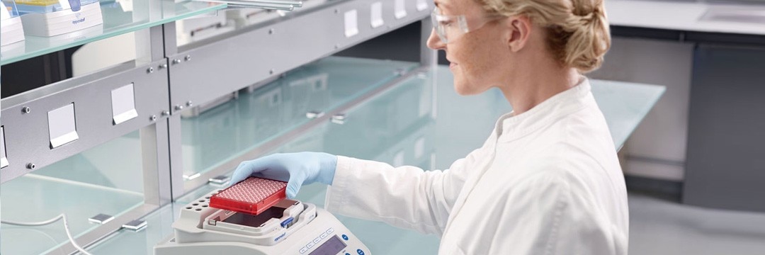 A scientist transfers samples into a temperature control and mixing instrument.