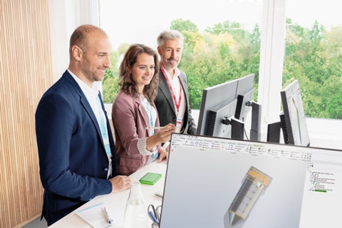 OEM developers office, three people looking at a monitor.