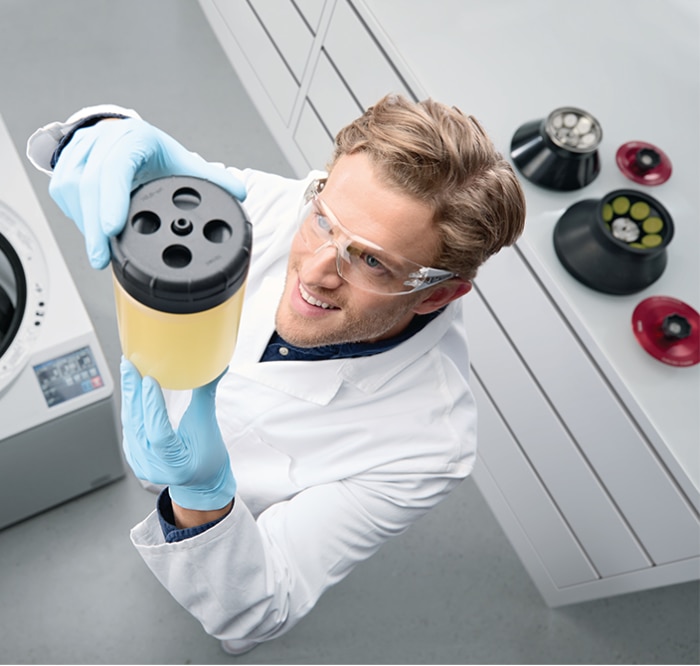 man in lab with Eppendorf centrifuge holding bottle