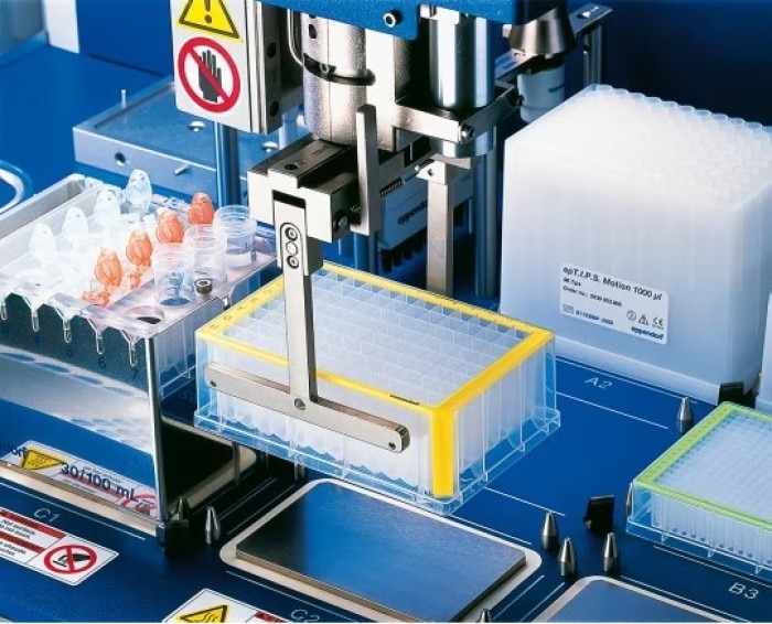 A liquid handling automation sample preparation gripper holds an Eppendorf Deepwell Plate with samples.