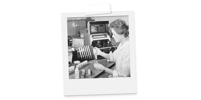 Image of a woman, working in lab with tubes, pipette and centrifuge