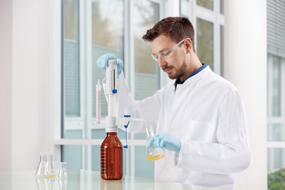 Lab technician using the Eppendorf Varispenser® 2x bottle-top dispenser to fill a glass vial Lab technician using the Eppendorf Varispenser® 2x bottle-top dispenser to fill a glass vial