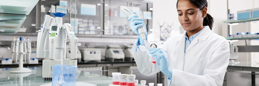 Laboratory scene with woman pipetting in 25mL Conical Tube