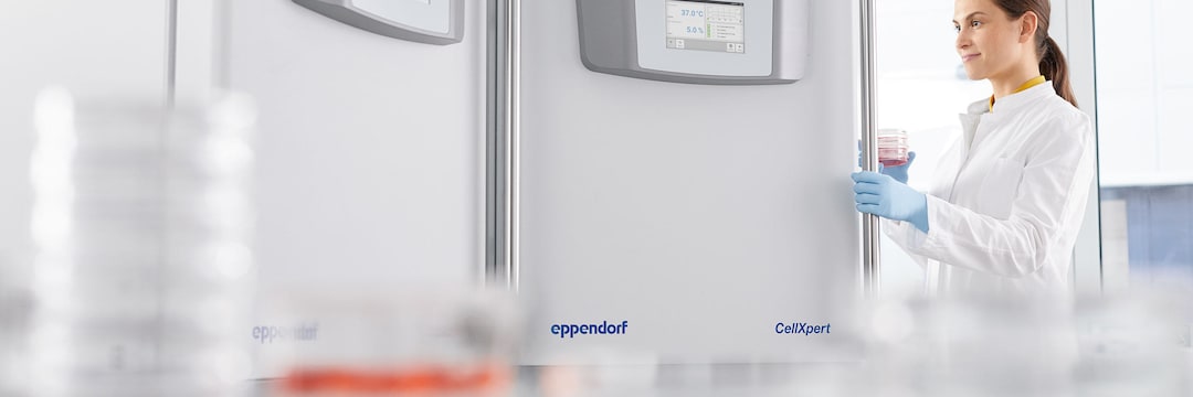 Female lab scientist opening door of Eppendorf shaker CellXpert C170i