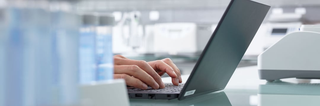 Hands on the keyboard of an opened laptop